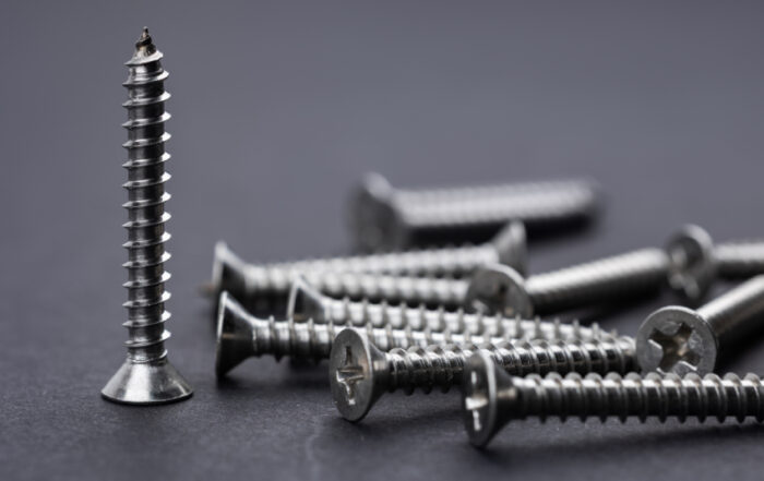 Tapping screws made of steel on Gray background, metal screw, iron screw, chrome screw,